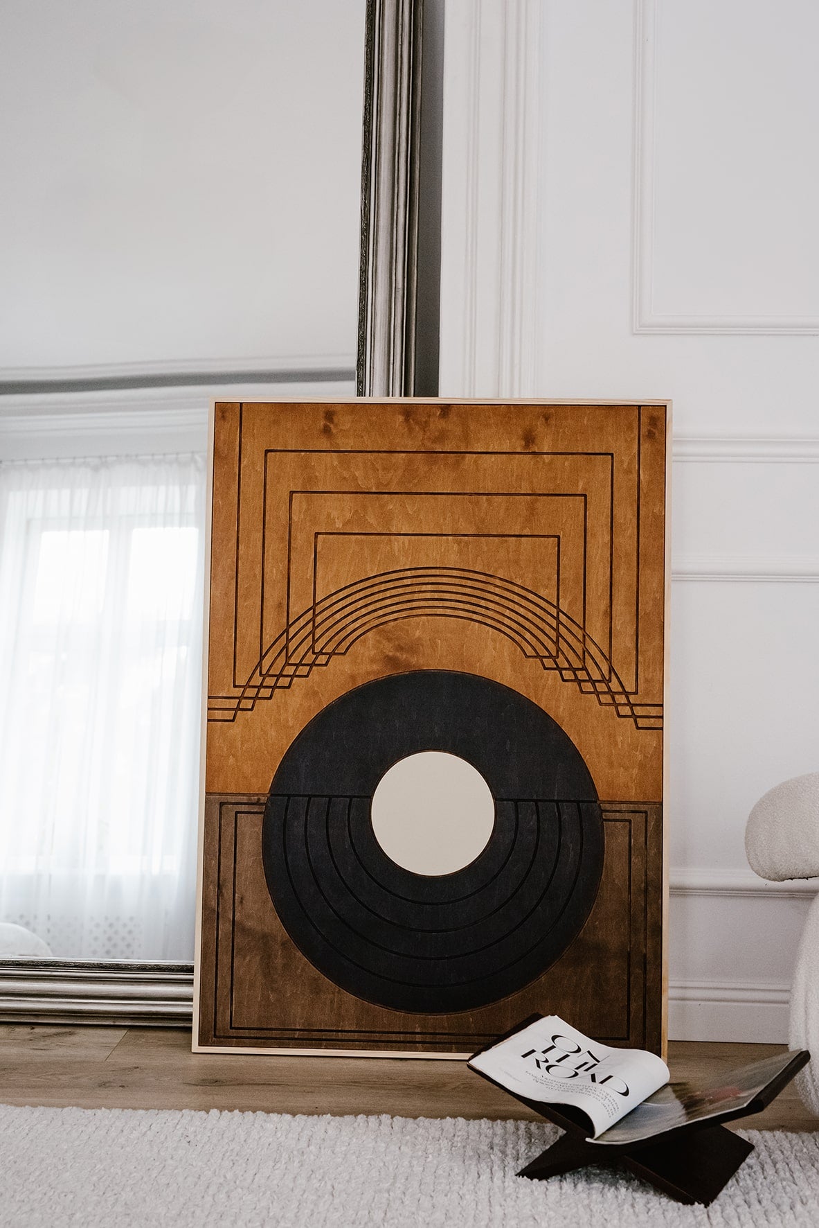 Ręcznie wykonana drewniana dekoracja ścienna DAWN o geometrycznym wzorze, oparta o lustro w jasnym wnętrzu