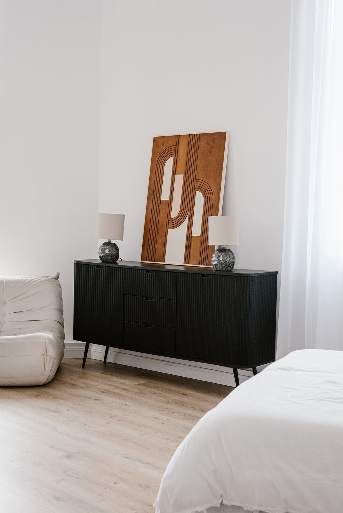 Drewniana dekoracja ścienna MODU ustawiona na komodzie, widok boczny w jasnym wnętrzu.