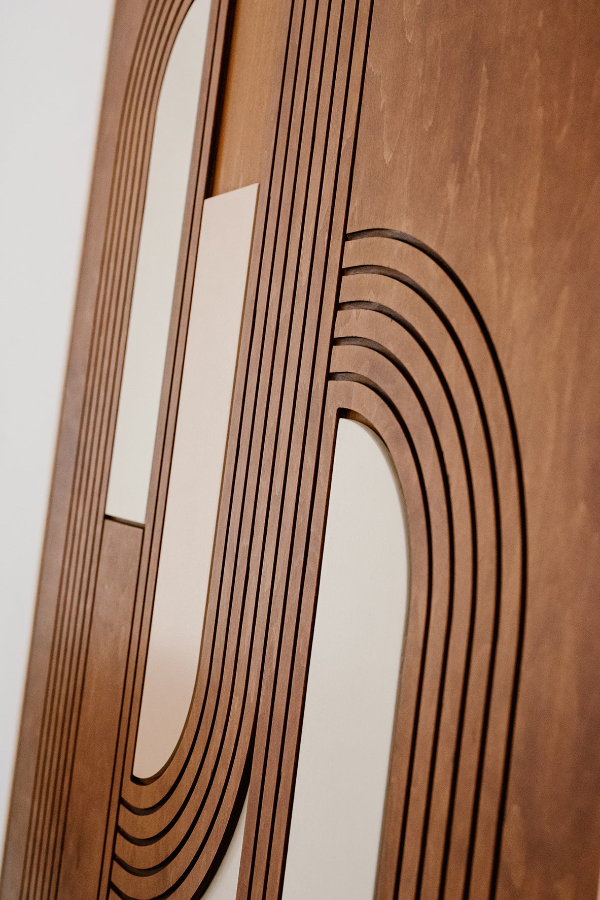 Zbliżenie na geometryczny, warstwowy wzór drewnianej dekoracji ściennej MODU.